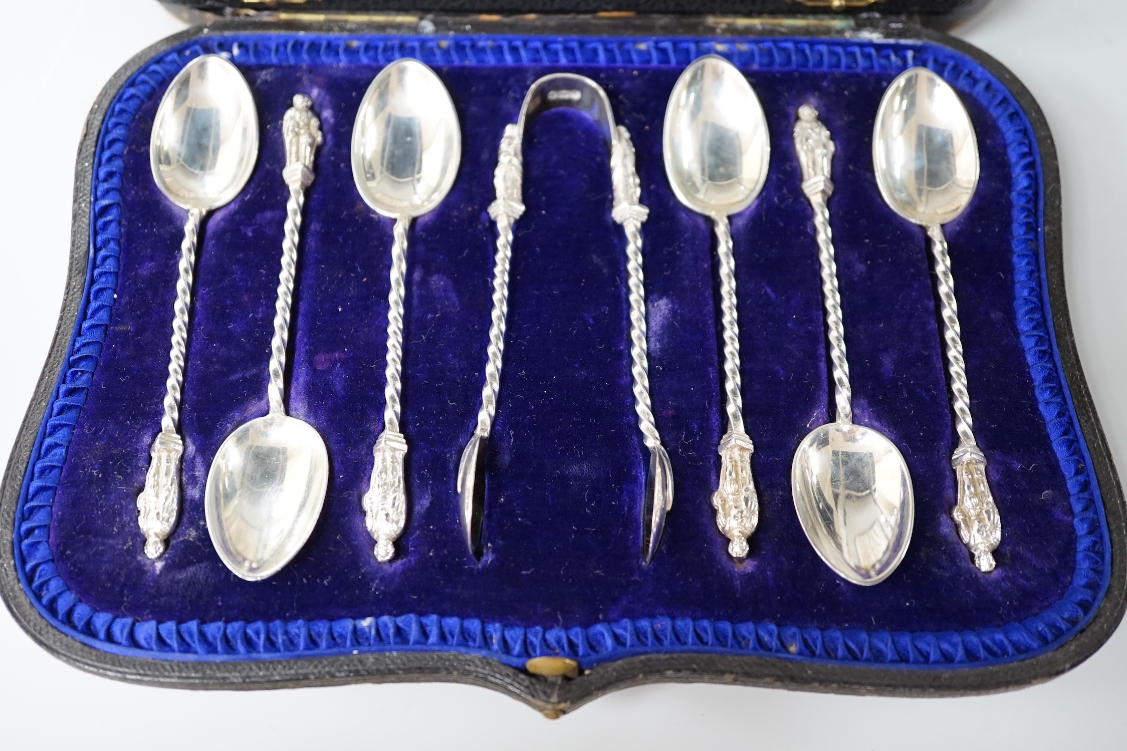 A cased set of six late Victorian silver apostle teaspoons and tongs, Sheffield 1900, 116 grams, and a set of six George VI silver handled cake knives, Sheffield 1957